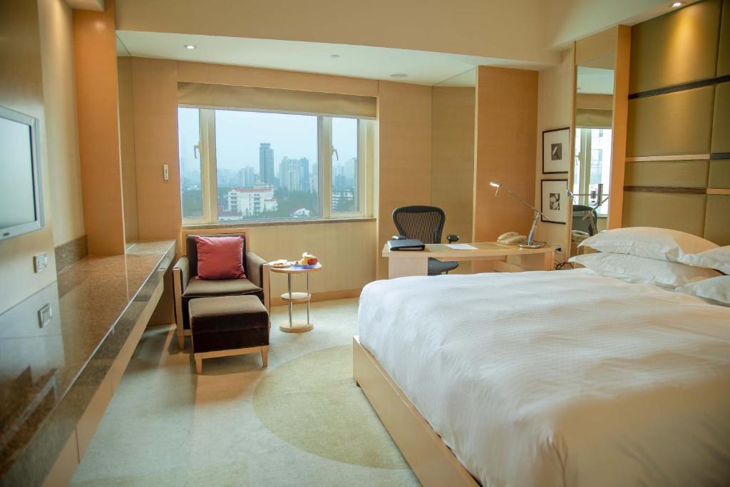 上海市にあるHengshan Garden Hotelの大きなベッドと窓が備わるホテルルームです。
