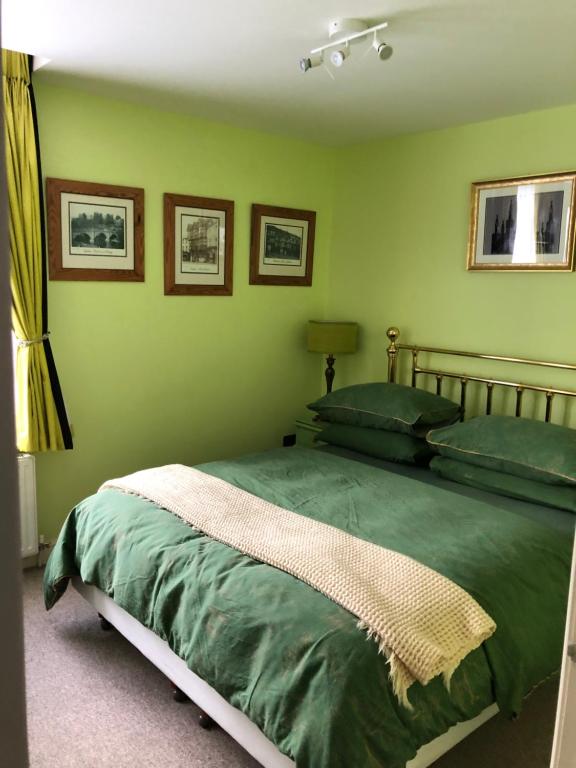 a bedroom with a bed with green walls at Flat G, 8 Castle Street in Ludlow