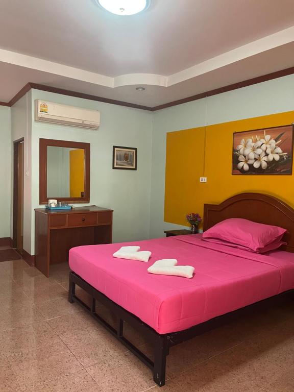 een slaapkamer met een groot roze bed en een spiegel bij เซเว่นอิน in Ban Huai Phlu