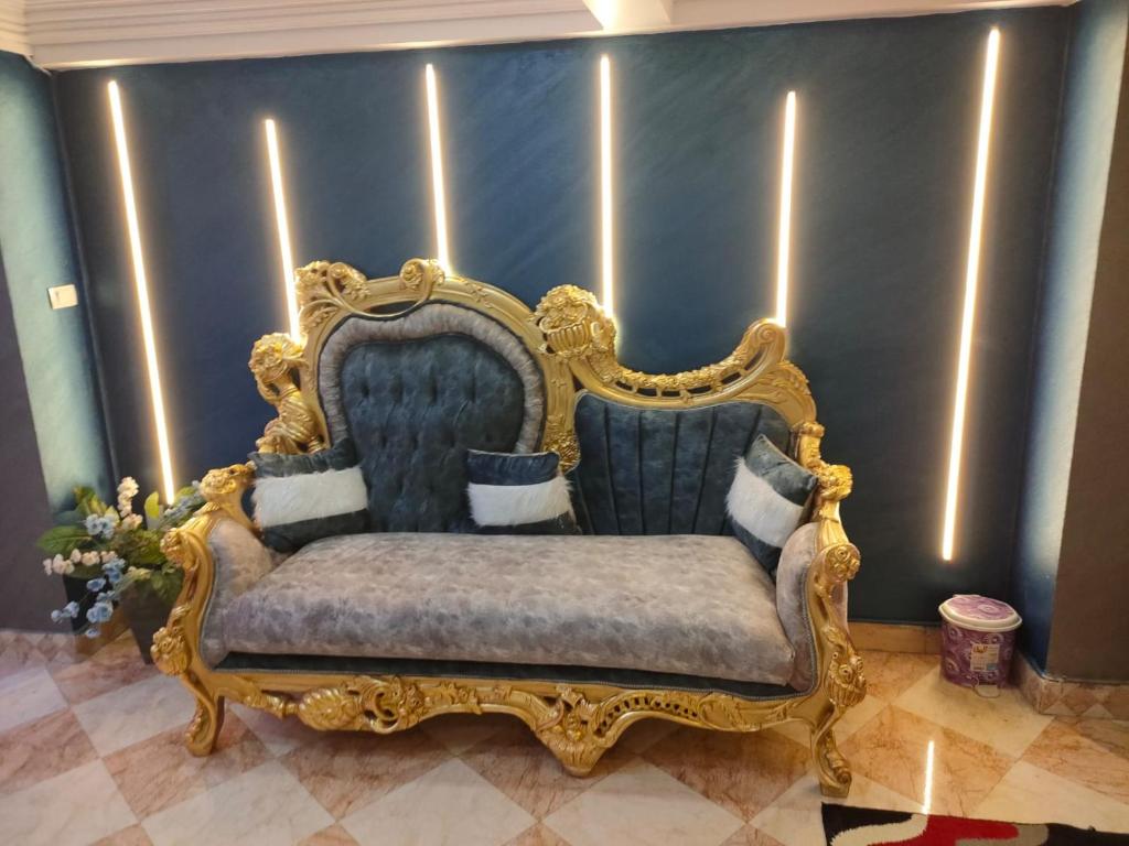 a gold and blue chair in a room at شقق المنيل in Cairo