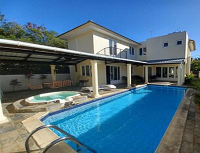 une grande piscine en face d'une maison dans l'établissement Magnifique Villa avec piscine privée à 550 m de la plage, à Trou aux Biches