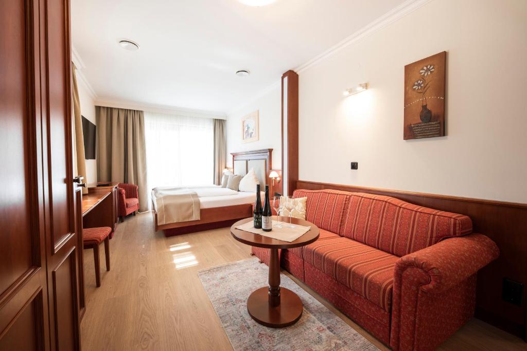 a hotel room with a couch and a bed at Boutiquehotel WEINSPITZ & Weingut STRAWANZER Donabaum in Spitz
