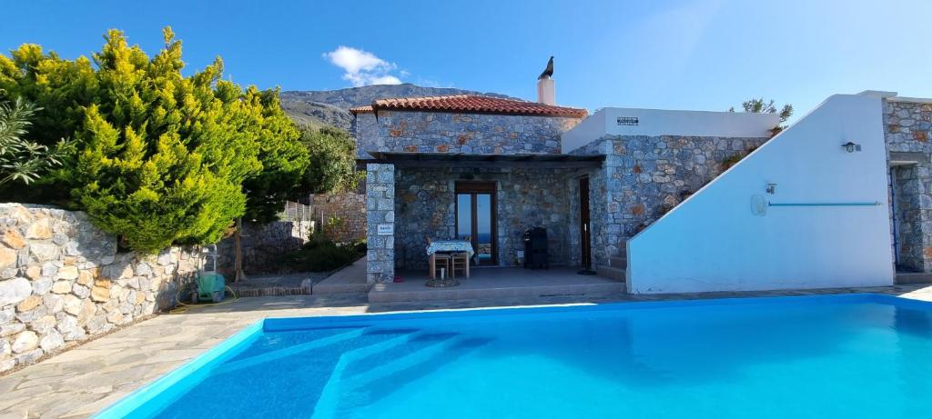 una villa con piscina di fronte a una casa di Villa Mavri Ruhige private Pool Villa, Meerblick ad Agia Paraskevi