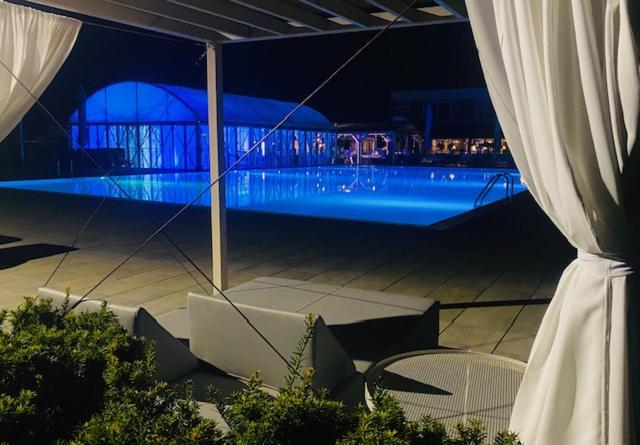 uma vista para uma piscina à noite em Kerkira pub&restaurant em Veľké Úľany