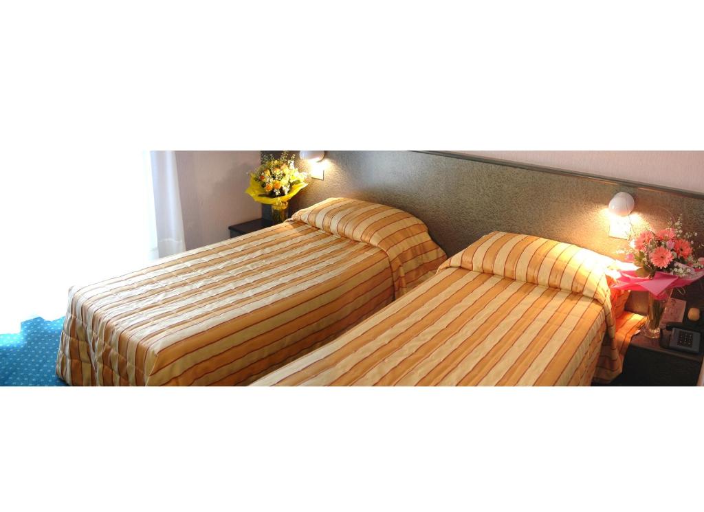 A bed or beds in a room at Hotel Capri Bardolino 3S