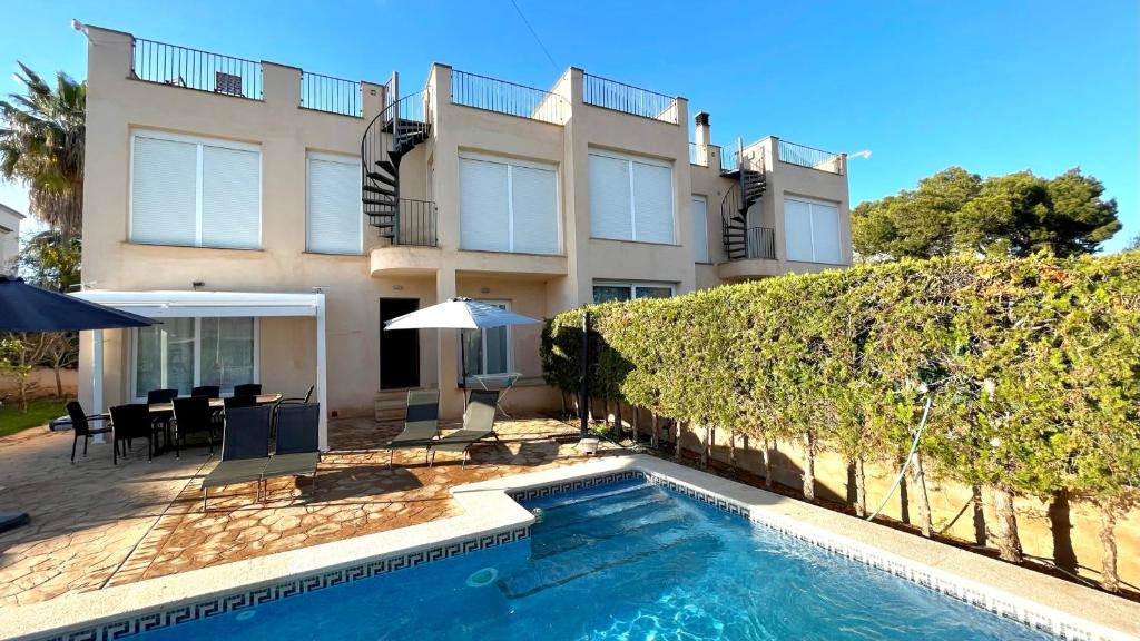 a house with a swimming pool in front of a house at Aina in Cala Pi