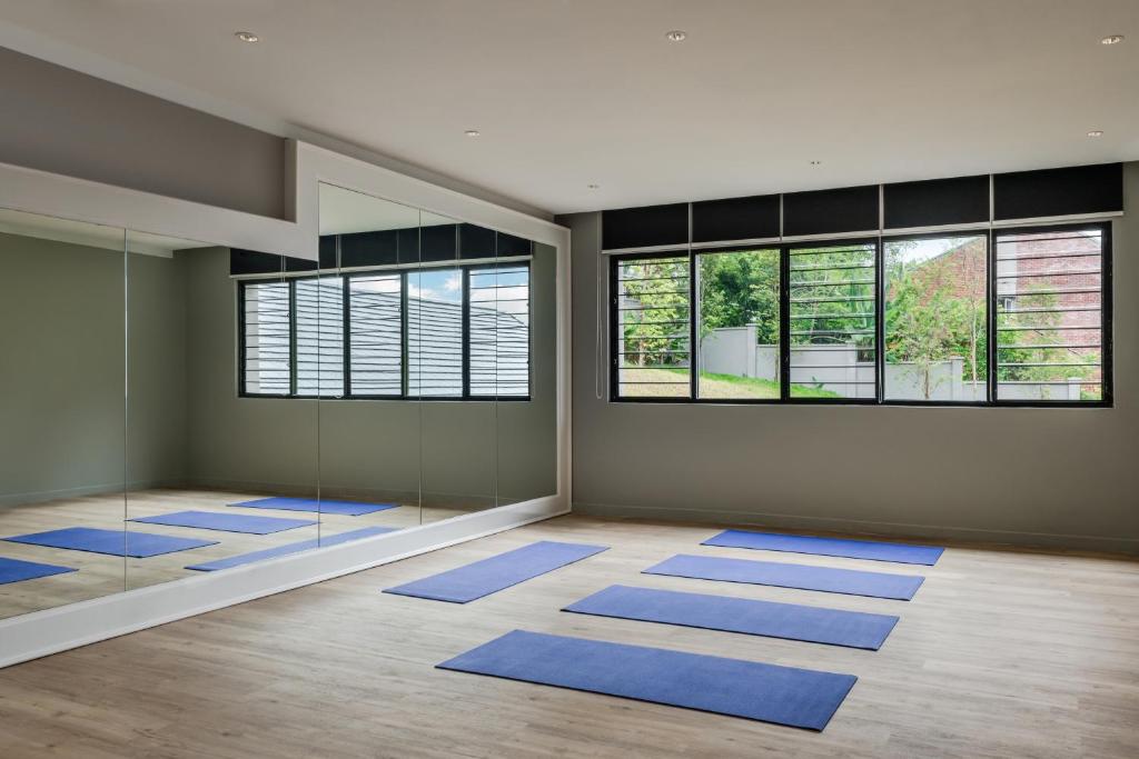 A bright mirrored studio set up with blue floor mats.