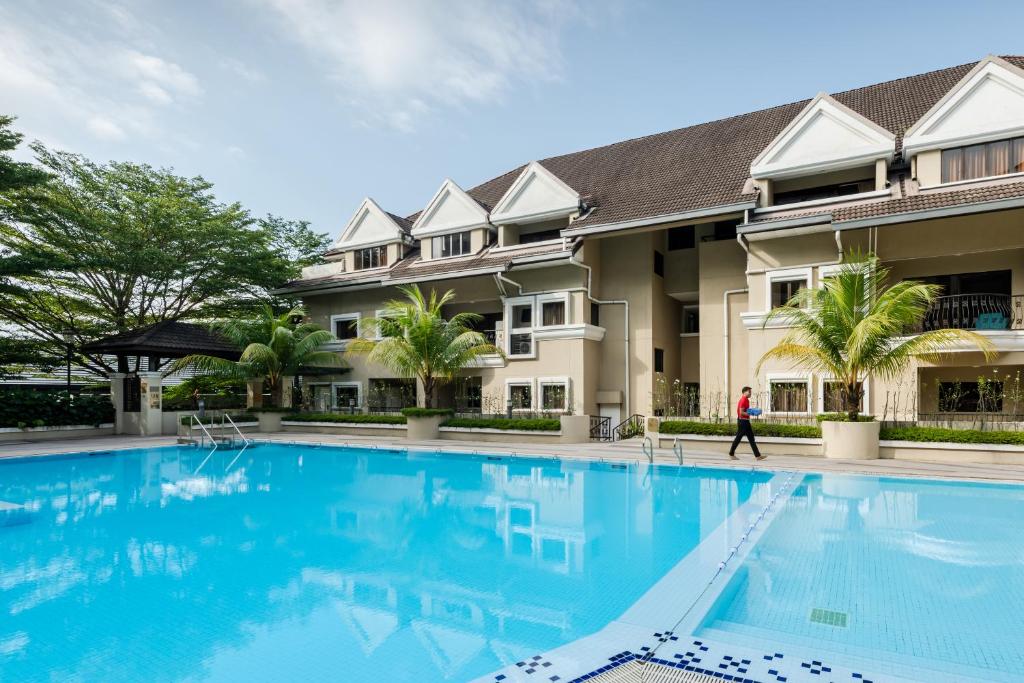 A wide daytime view of the outdoor pool and the buildings around it.