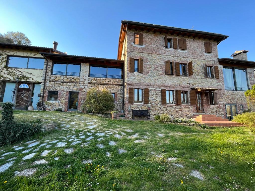 un antiguo edificio de piedra con un patio de césped en B&B A Casa Mia, en Marostica