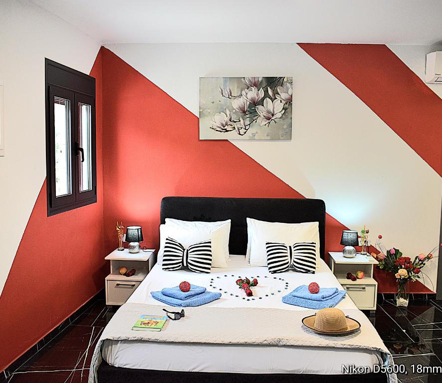 a bedroom with a bed with a red wall at Istron Corner Apartments in Istro
