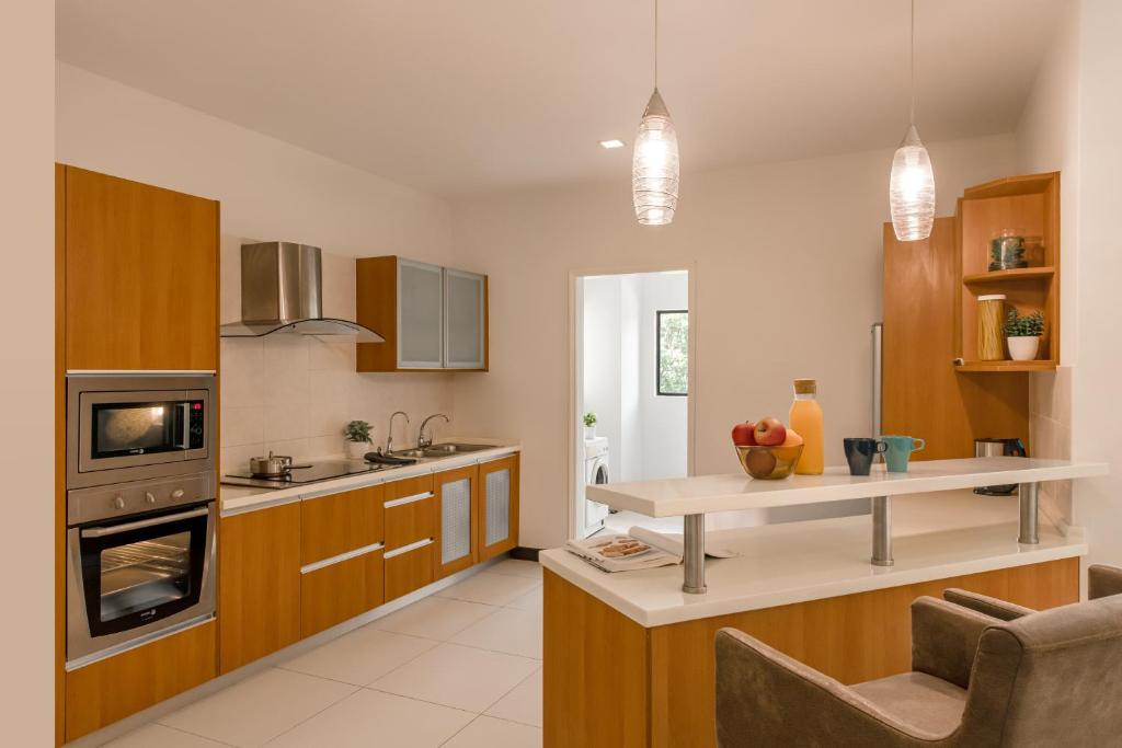 A bright fitted kitchen with a breakfast counter and built-in appliances.