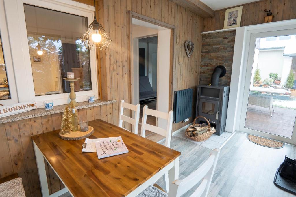 uma sala de jantar com uma mesa e um fogão a lenha em Harznester - Ferienhaus am Horstberg em Wernigerode