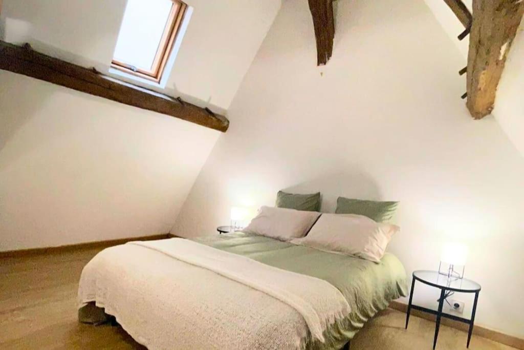 - une chambre avec un lit dans une pièce dotée d'une fenêtre dans l'établissement Atypique - Centre historique - Appartement 2 chambres, à Bourges