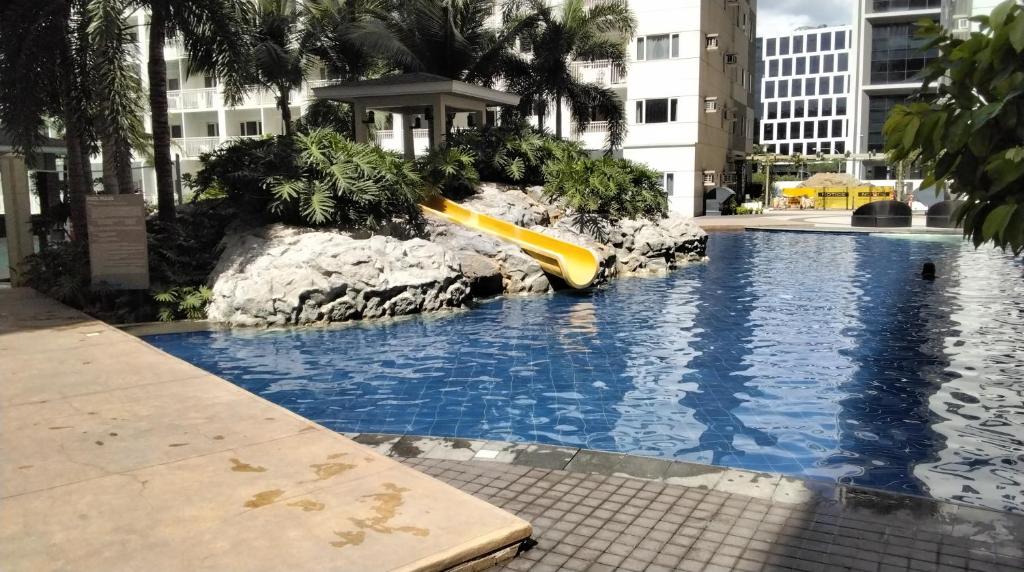 een gele glijbaan midden in een zwembad bij Shore 1 Residence Tower C2 - MOA in Manilla