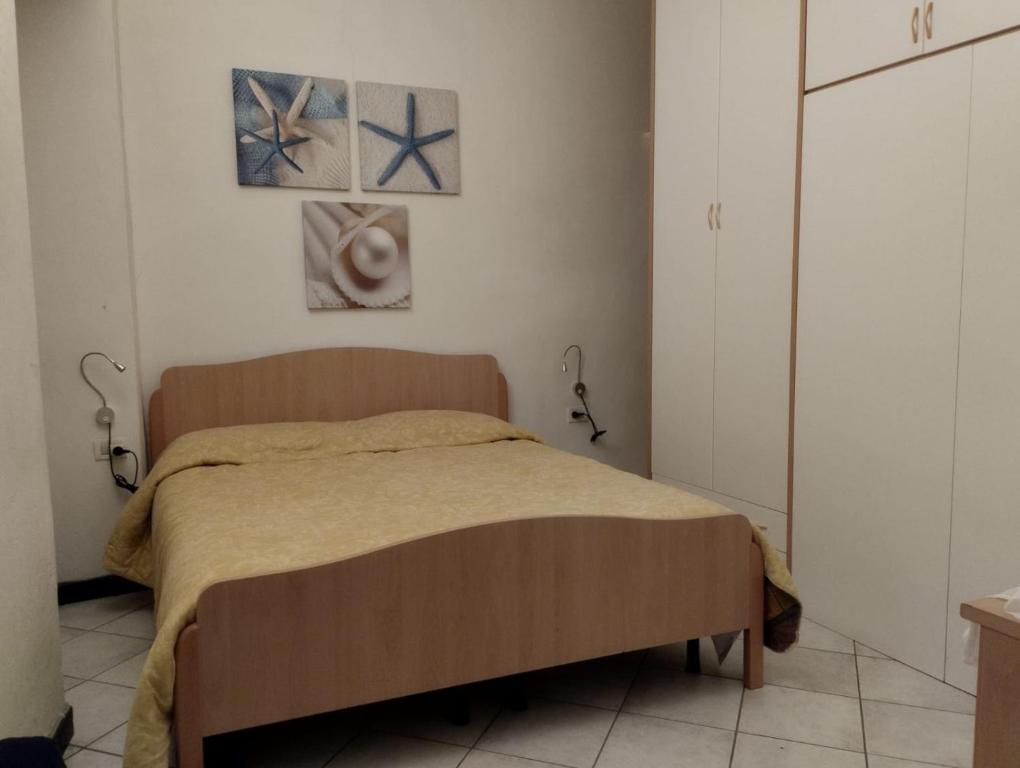 1 dormitorio con 1 cama y 2 cuadros en la pared en Il poggiolo di Rio, en Riomaggiore