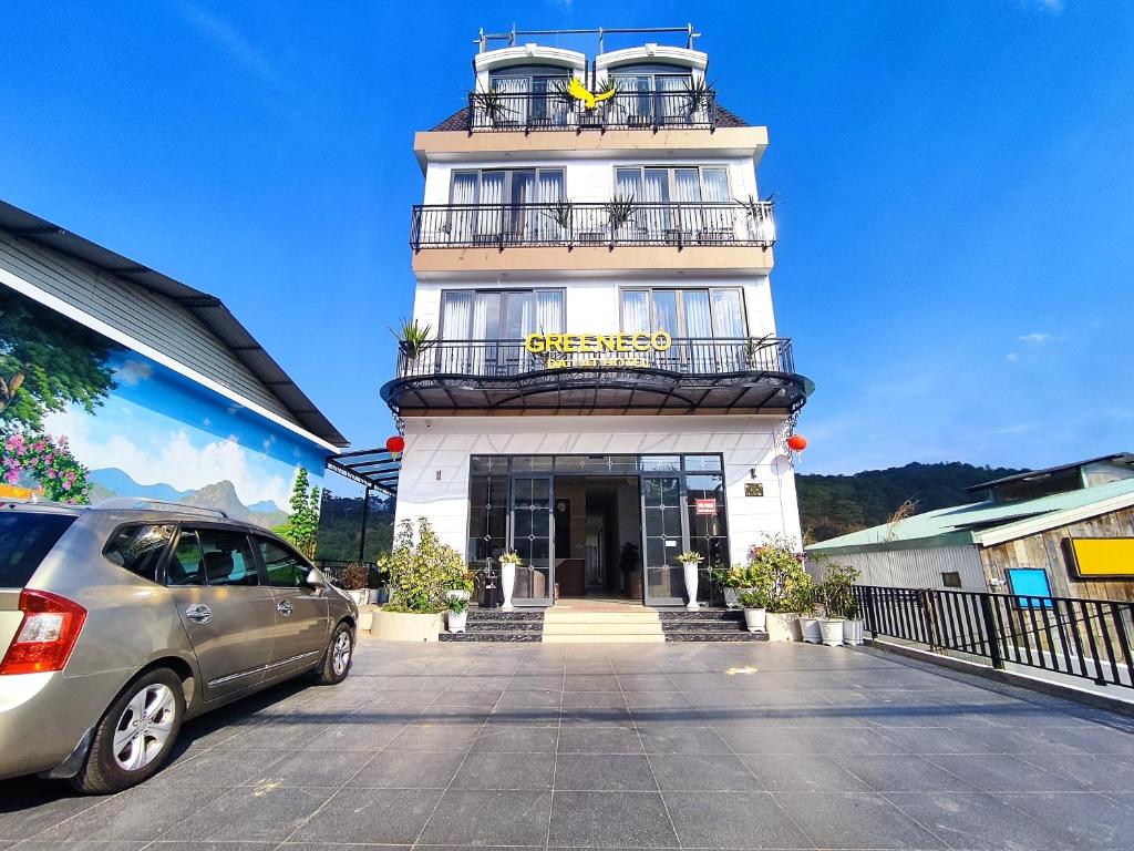 un edificio con un coche aparcado delante de él en GREENECO DA LAT HOTEL - Khách sạn Green Eco Đà Lạt en Da Lat