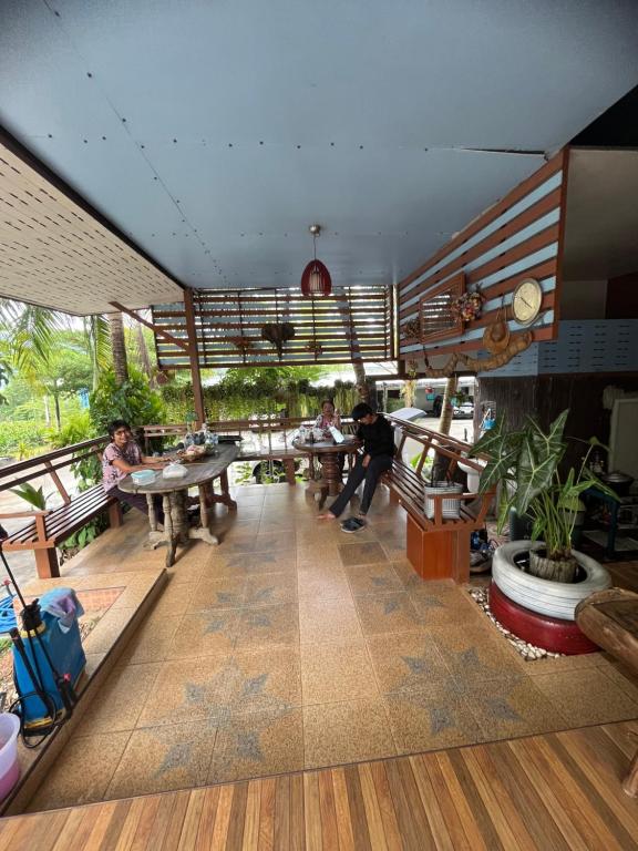un restaurante con mesas y personas sentadas en mesas en Seven-in en Ban Khlong Chi Lat