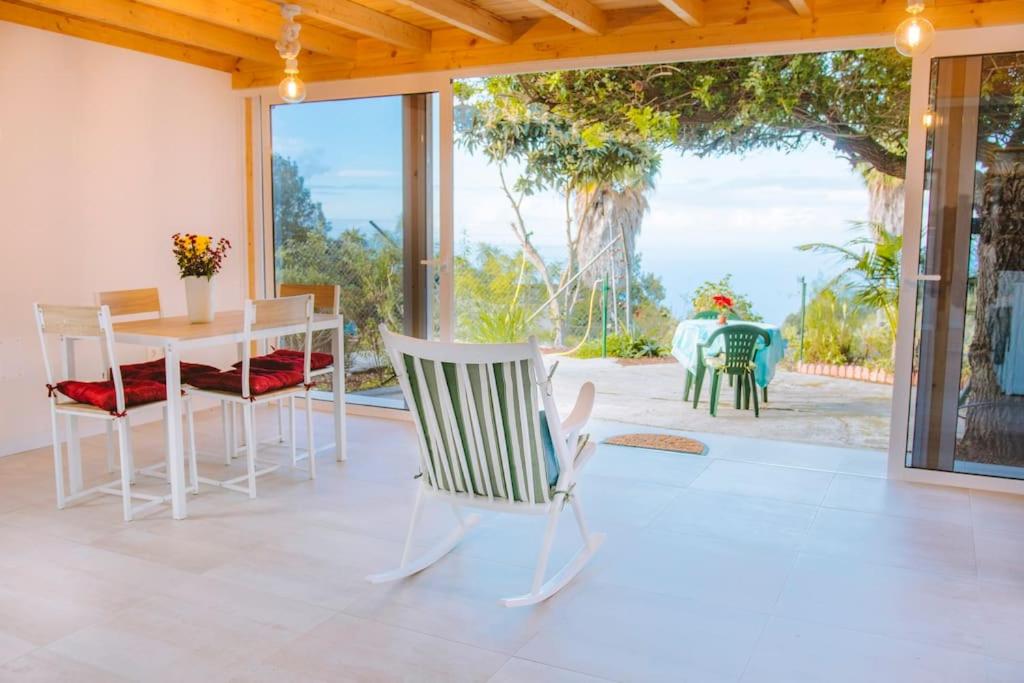 ein Wohnzimmer mit einem Tisch und Stühlen sowie eine Terrasse in der Unterkunft Casita Gopal in Icod de los Vinos