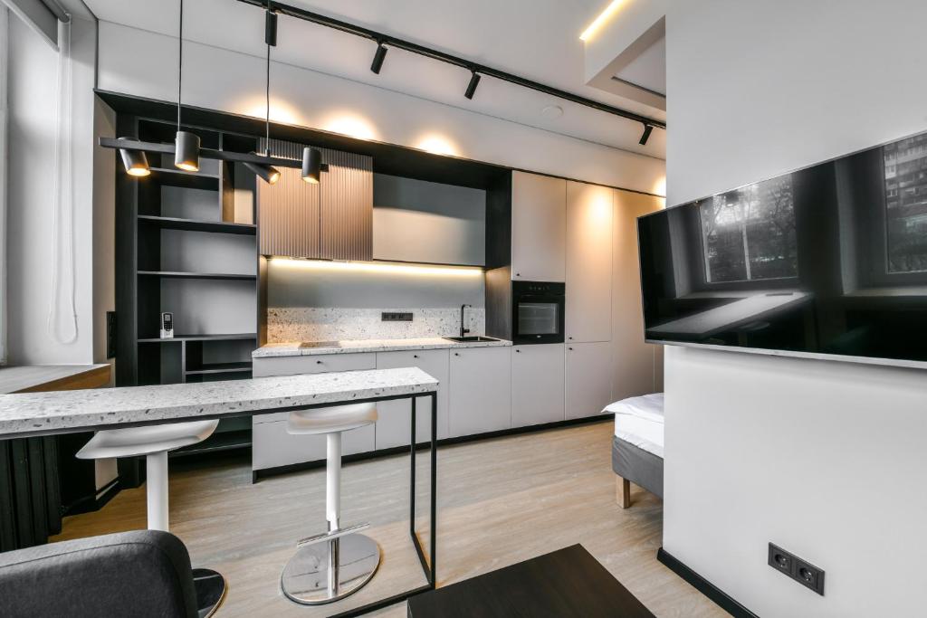 a kitchen with white cabinets and a counter top at Apartments near Ozas in Vilnius