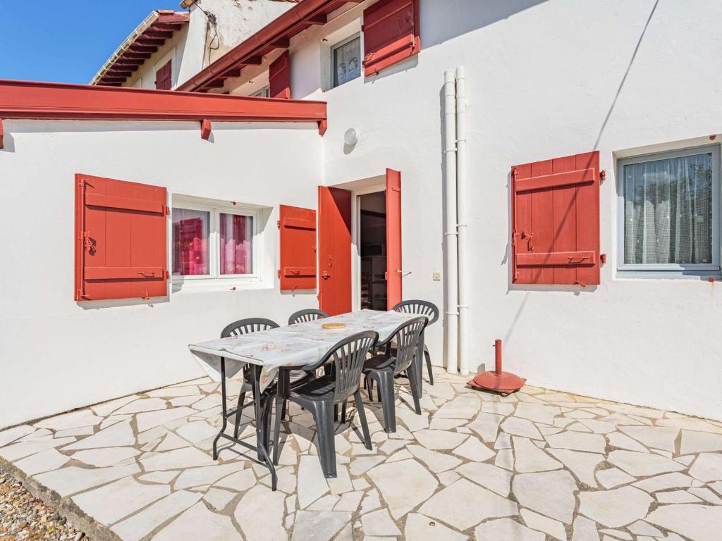 un patio avec une table et des chaises devant un bâtiment dans l'établissement Plage d'Erromardie à 300m : Maison Basque avec Terrasse, 3 Chambres et Parking - FR-1-4-589, à Saint-Jean-de-Luz