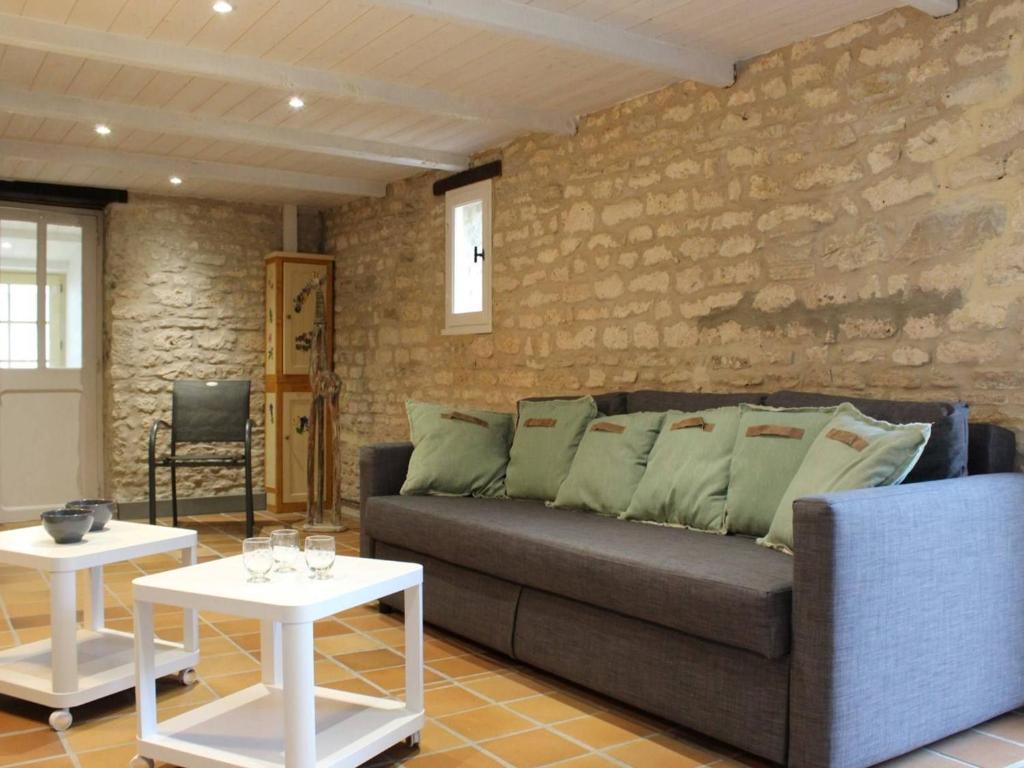 un salon avec un canapé et deux tables dans l'établissement Maison Charme Ancien, Jardin, 2Km Centre St Pierre, 20min Plage - 5 Couchages - FR-1-246A-65, à Saint-Pierre-dʼOléron