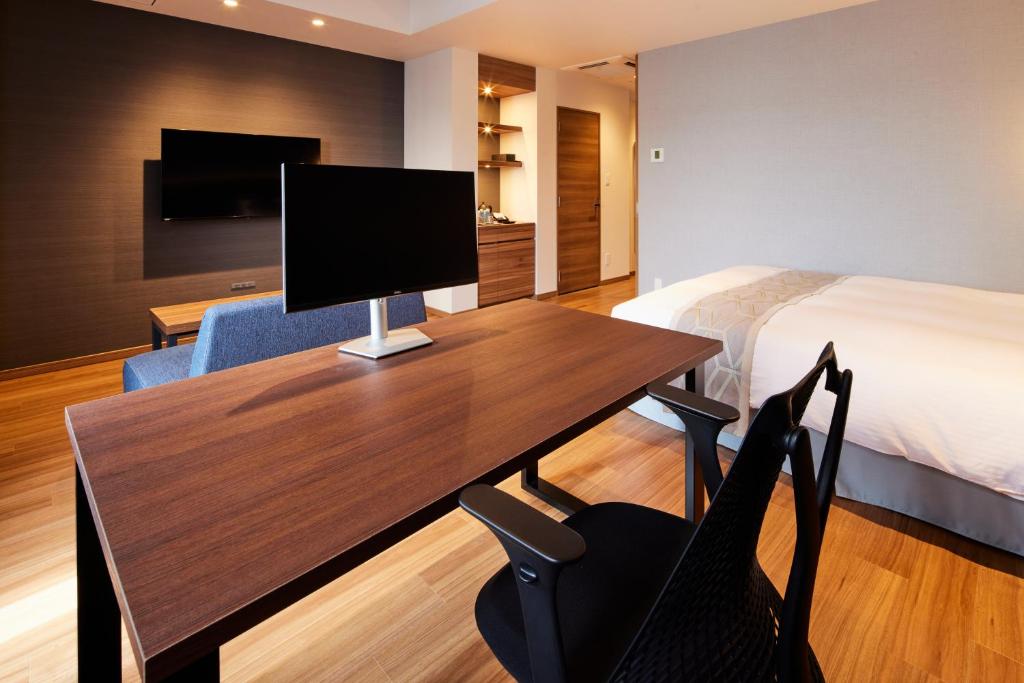 a hotel room with a desk with a computer on it at HOTEL SAILS in Osaka