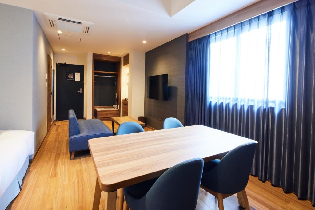 a hotel room with a table and blue chairs at HOTEL SAILS in Osaka