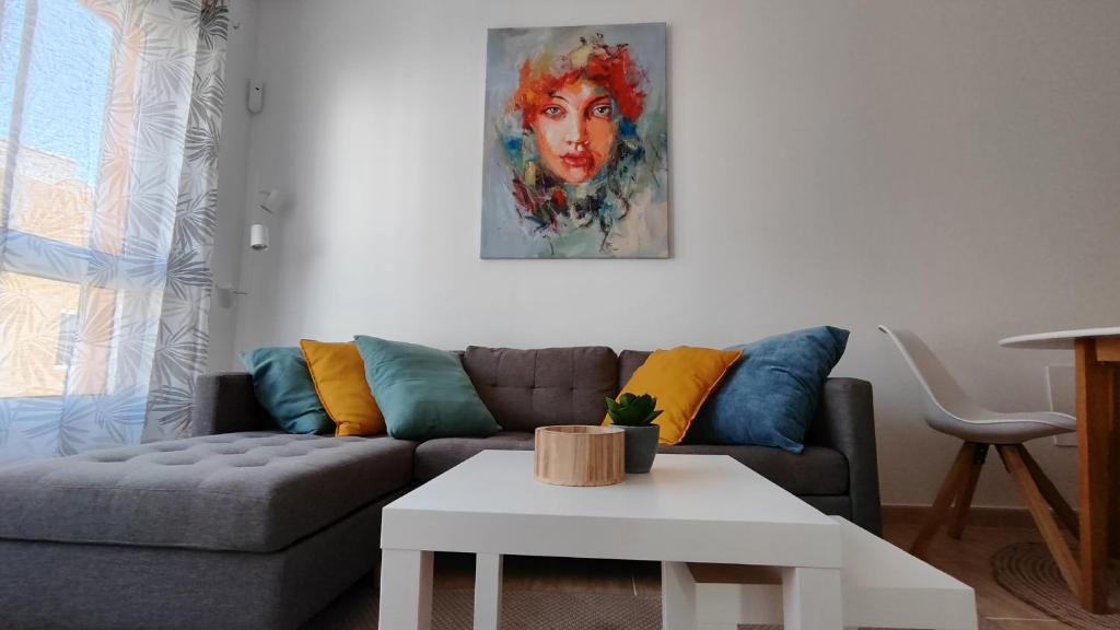 ein Wohnzimmer mit einem Sofa und einem Tisch in der Unterkunft Puipana Apartment, Fuerteventura in Puerto del Rosario