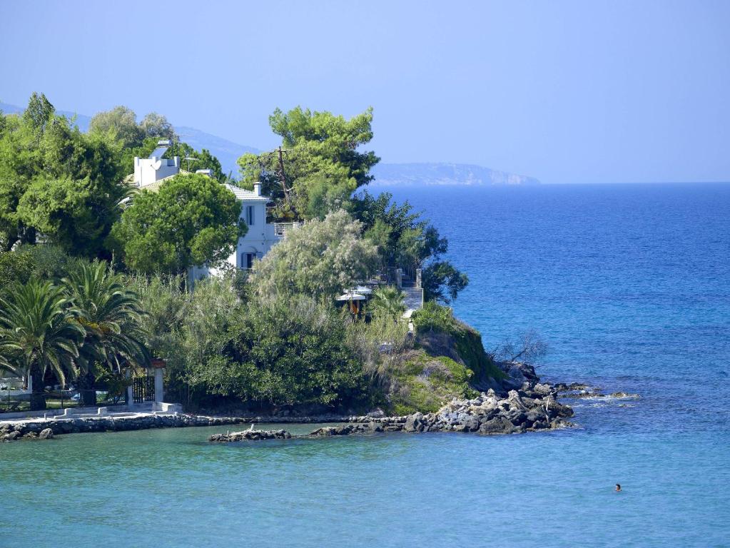 a house on a small island in the water at Paradisso Beach Villas in Amoudi