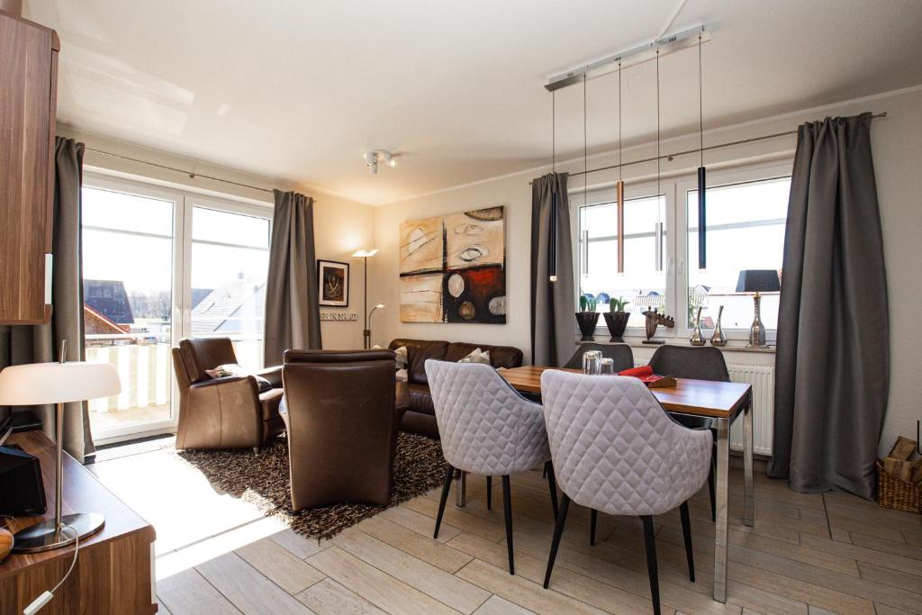 - un salon avec une table et des chaises ainsi qu'une salle à manger dans l'établissement Villa Bernstein Wohnung 06, à Boltenhagen