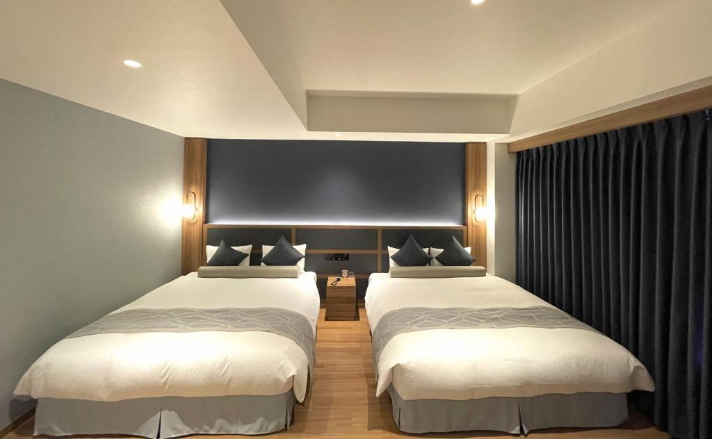 two beds in a hotel room with two beds sidx sidx sidx at HOTEL SAILS in Osaka