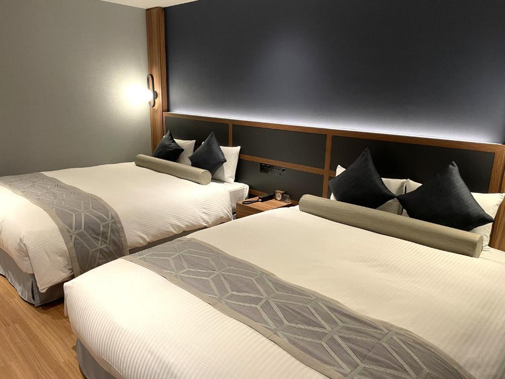 a hotel room with two beds with white sheets at HOTEL SAILS in Osaka