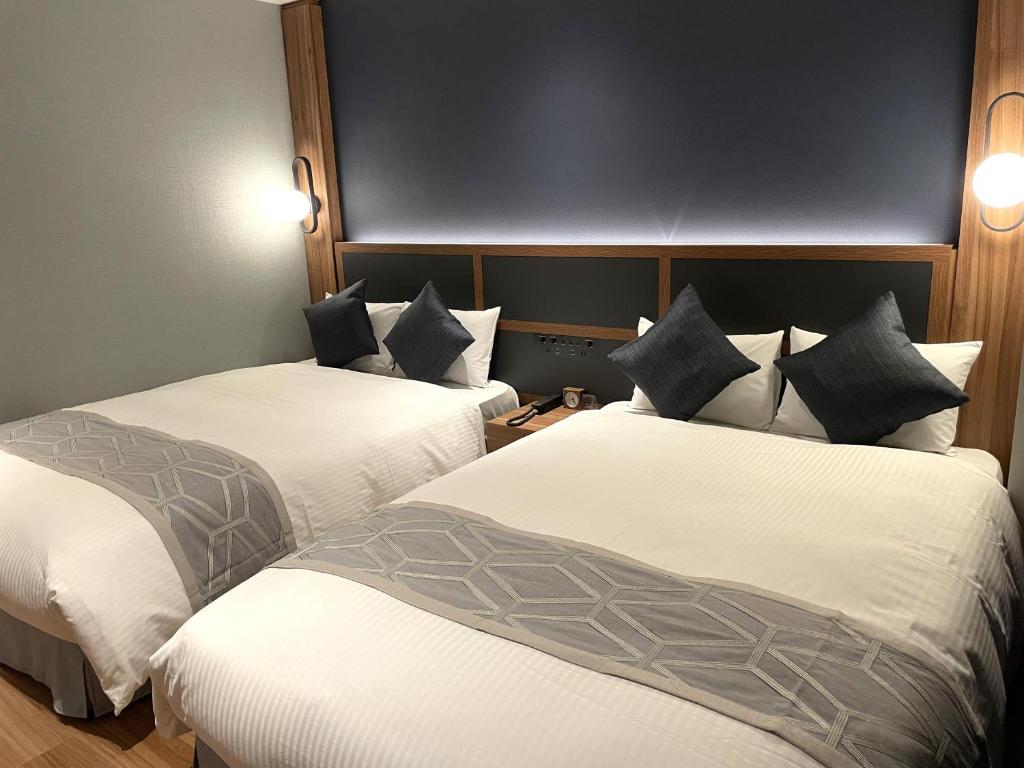 a hotel room with two beds with white sheets at HOTEL SAILS in Osaka
