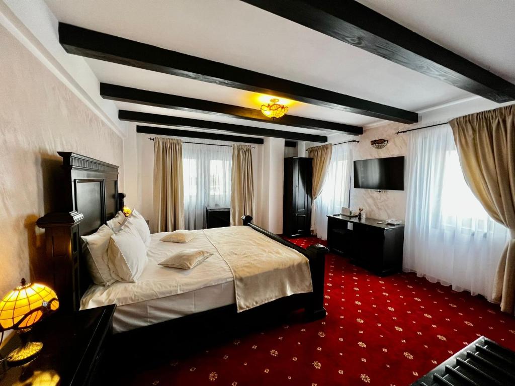 Podu' cu Lanturi في باكاو: غرفة نوم بسرير كبير وسجادة حمراء