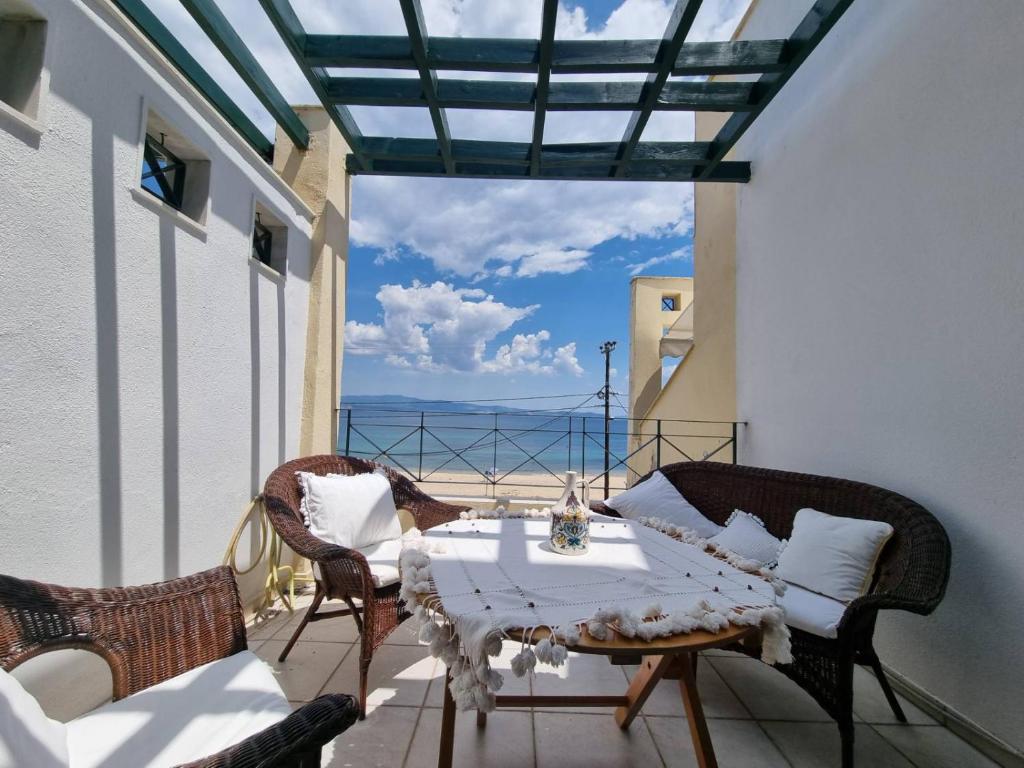 a balcony with a table and chairs and a view of the ocean at Cosy apartment by the sea in Nea Potidaea