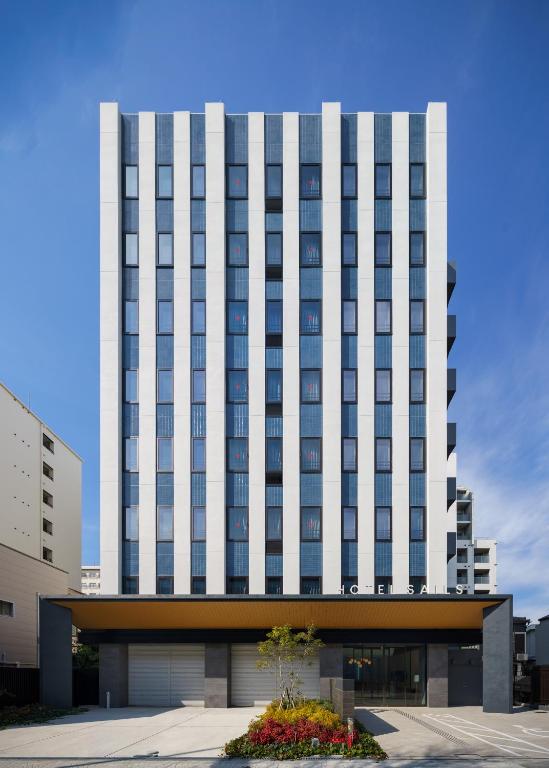 a tall white building with a lot of windows at HOTEL SAILS in Osaka