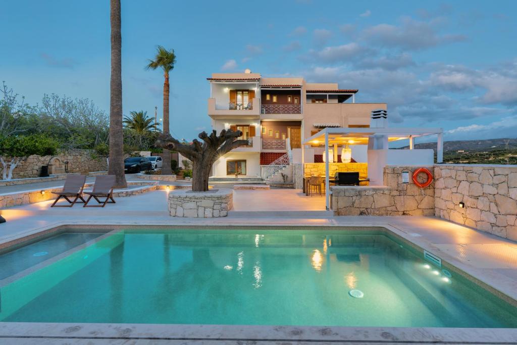 une maison avec une piscine en face d'une maison dans l'établissement La Serena Residence & Farm with Heated Pool, à Réthymnon