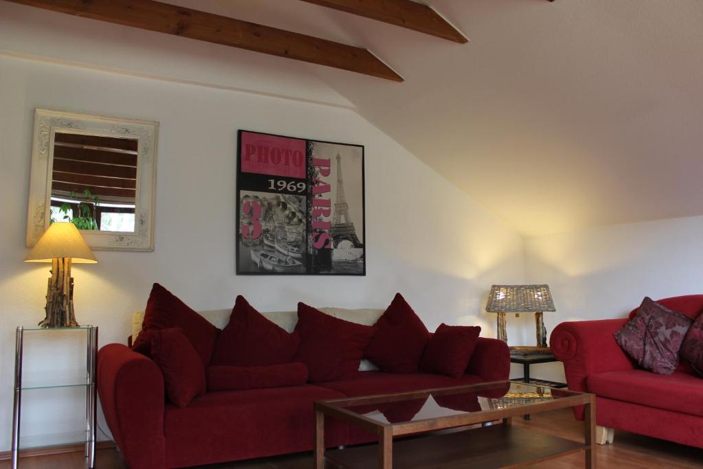 een woonkamer met twee rode banken en een tafel bij Apartment Ramersdorf in Bonn
