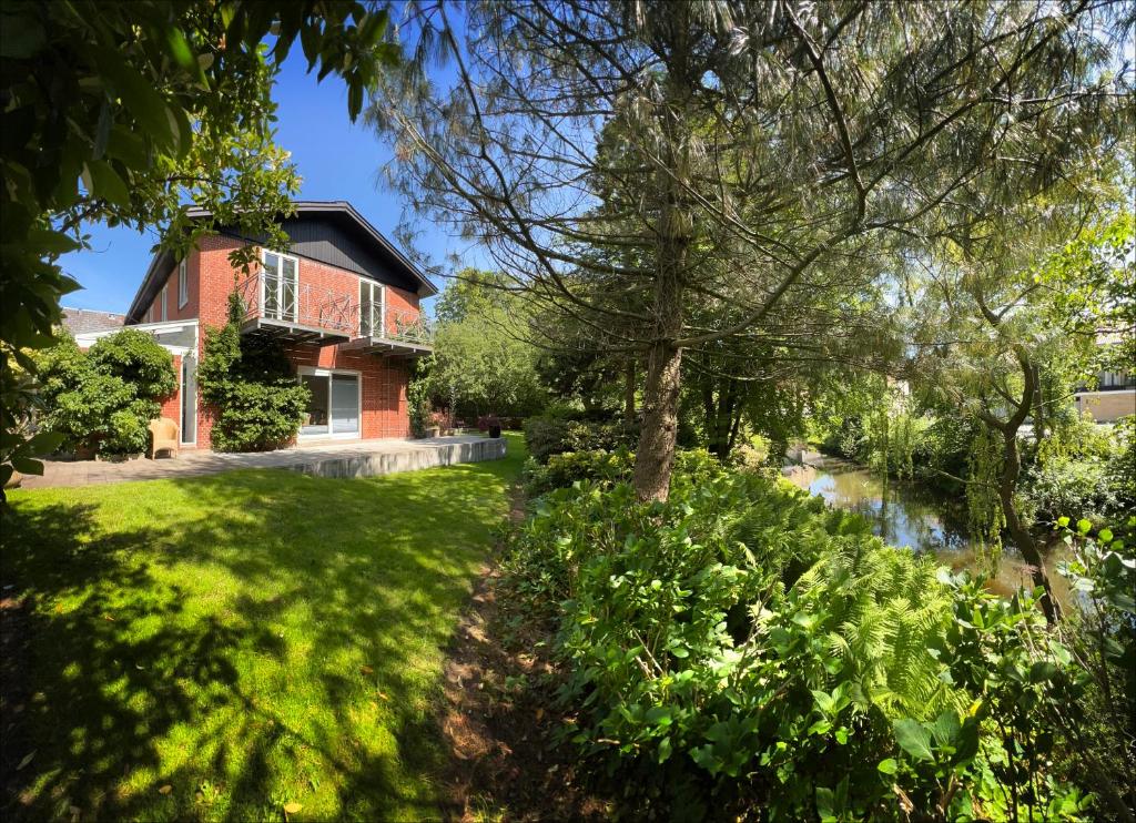 une maison avec un arbre dans la cour dans l'établissement Hotel Aahøj, à Sæby