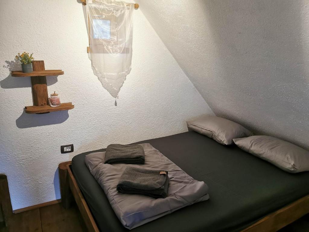a bed with two pillows on it in a room at Apartma Kačwa in Kobarid