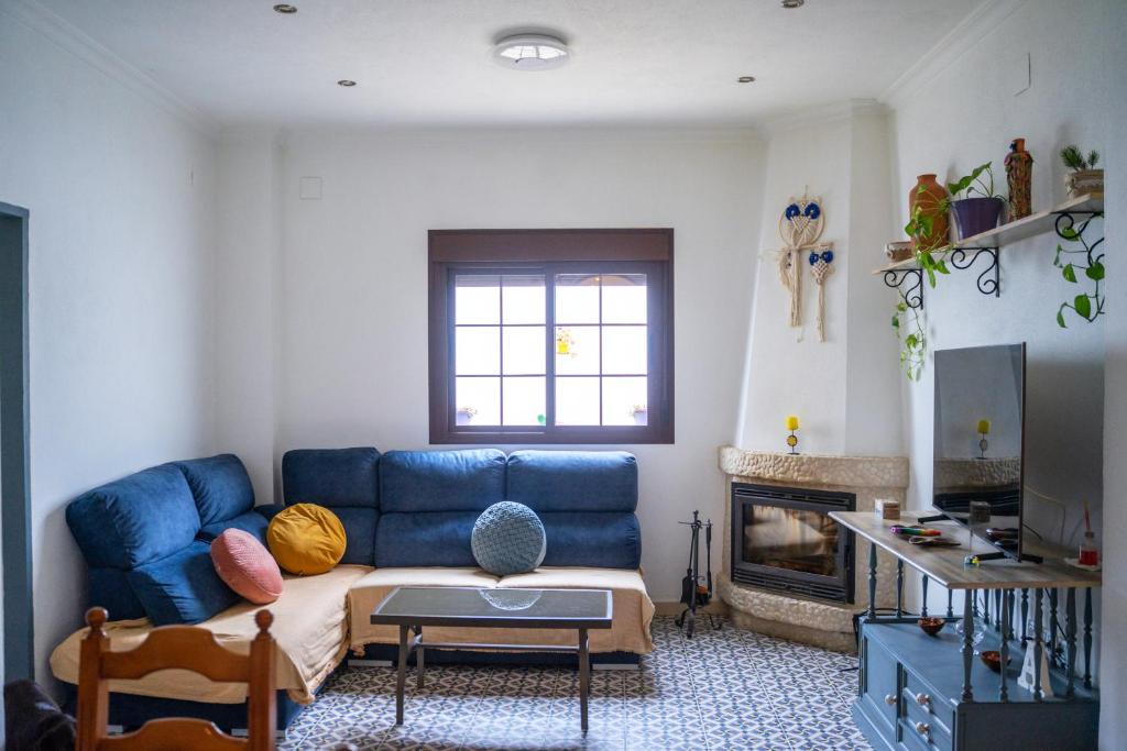 sala de estar con sofá azul y chimenea en La Casona de Alba, en Encinasola