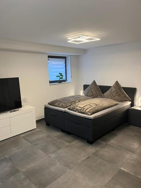 a bedroom with a bed and a flat screen tv at Ferienwohnung Emilia in Cologne