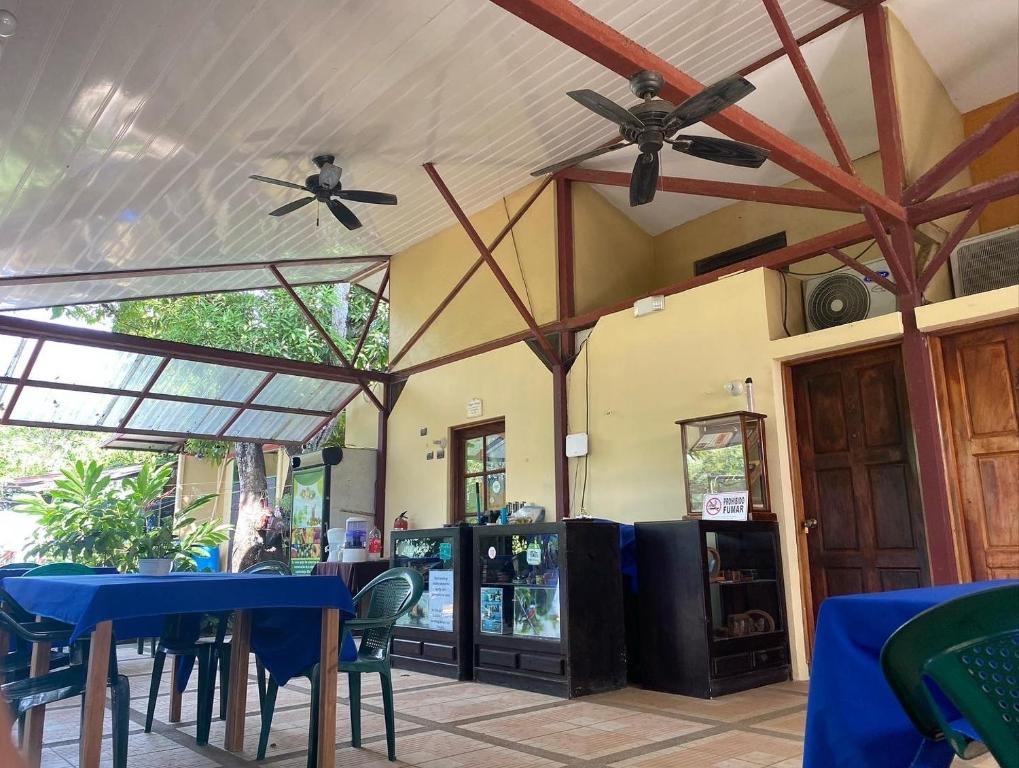 a dining room with a blue table and chairs at Cabinas surf Arribadas in Ostional