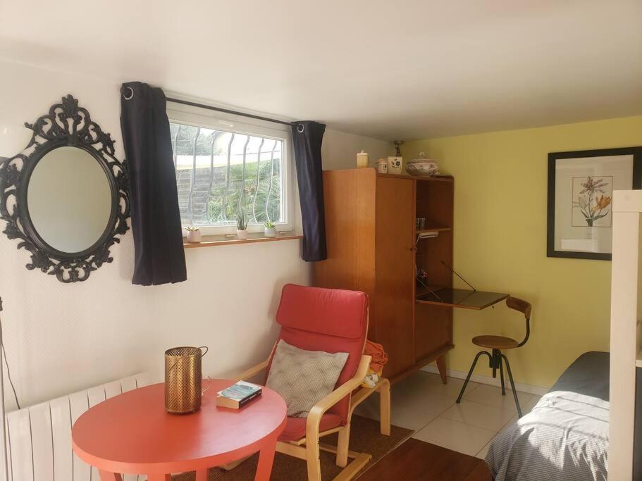 Cette chambre comprend une table, une chaise et un miroir. dans l'établissement Studio Buena Vista avec terrasse sur jardin, à Bron