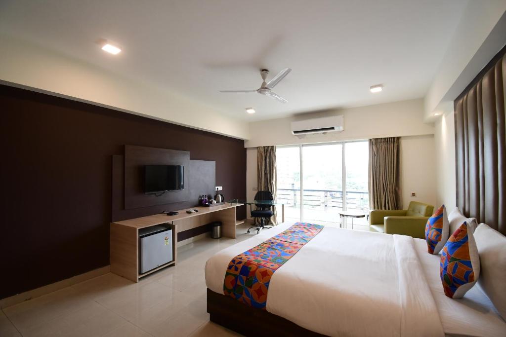 a hotel room with a bed and a television at The Xen Suites, Kolkata Airport in Kolkata