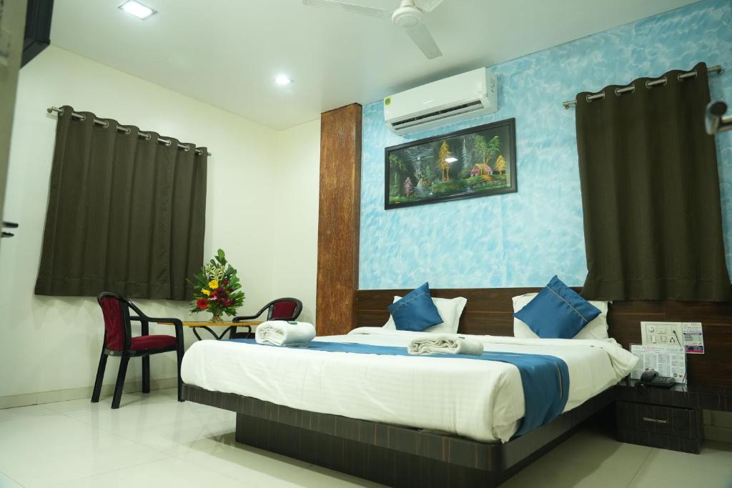a bedroom with a large bed with blue walls at Hotel Avon International in Aurangabad
