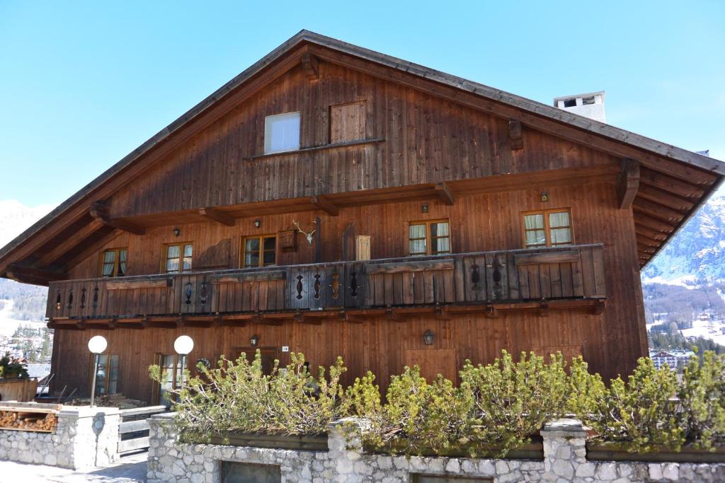 un gran edificio de madera con balcón. en Villa Ronco - Stayincortina, en Cortina dʼAmpezzo