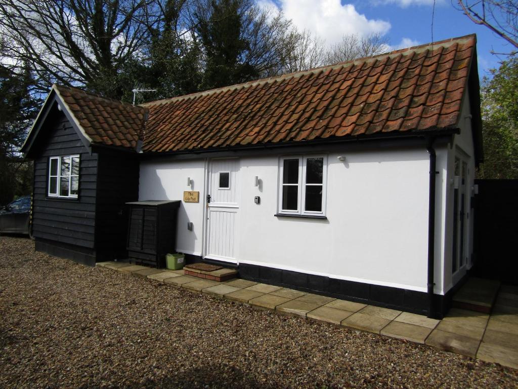 Thornham Magna的住宿－The Lily Pad Suffolk，白色车库,设有棕色屋顶