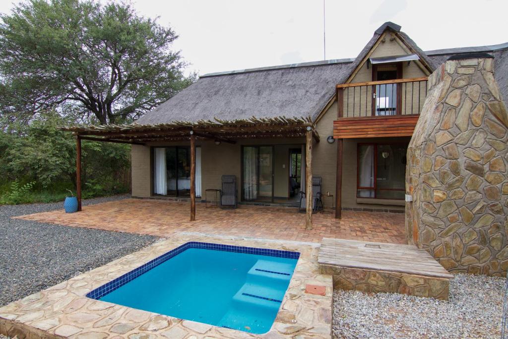 a house with a swimming pool in front of it at Ingwe Bush Lodge in Hoedspruit