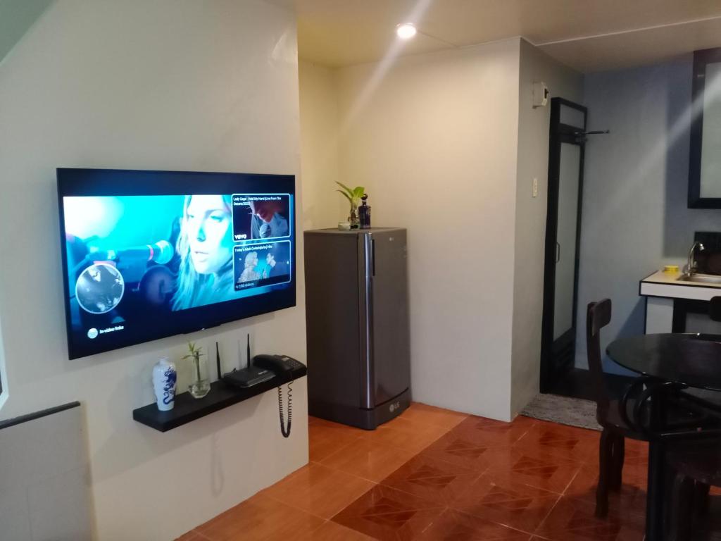 Z&J Transient House في بوتوان: غرفة معيشة مع تلفزيون بشاشة مسطحة على جدار